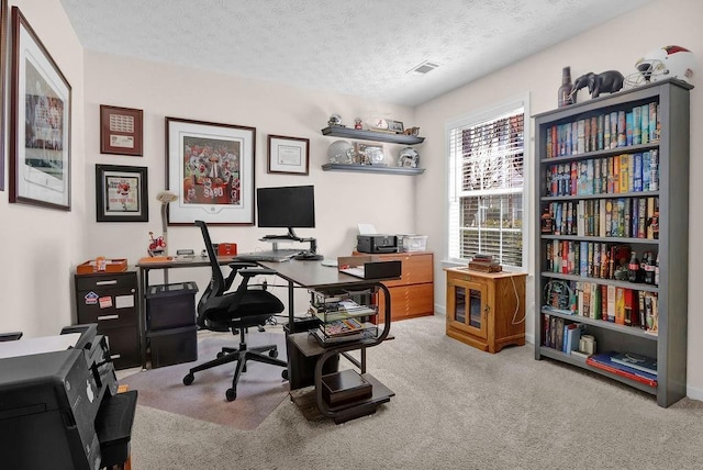 carpeted home office featuring visible vents and a textured ceiling