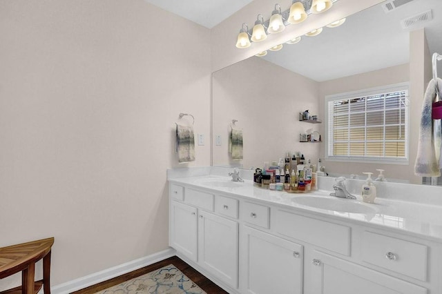 bathroom featuring double vanity, baseboards, visible vents, and a sink