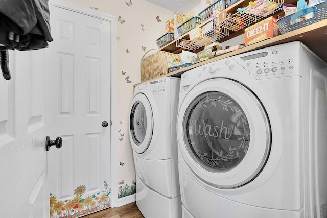 washroom featuring washer and dryer, laundry area, and wood finished floors