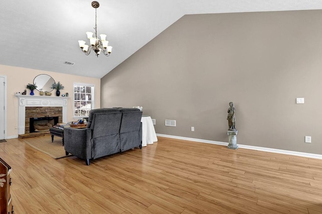 living area with baseboards, visible vents, a fireplace, and light wood finished floors