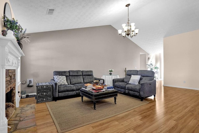 living area featuring a fireplace, a notable chandelier, visible vents, light wood-style floors, and baseboards