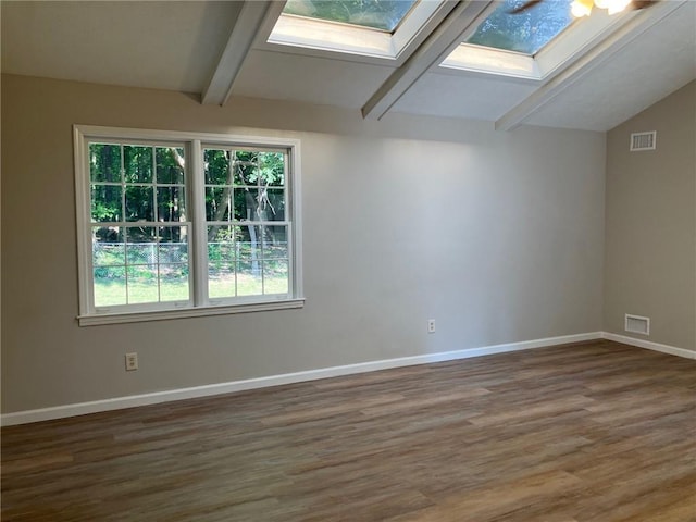 empty room with dark wood-type flooring and vaulted ceiling with skylight