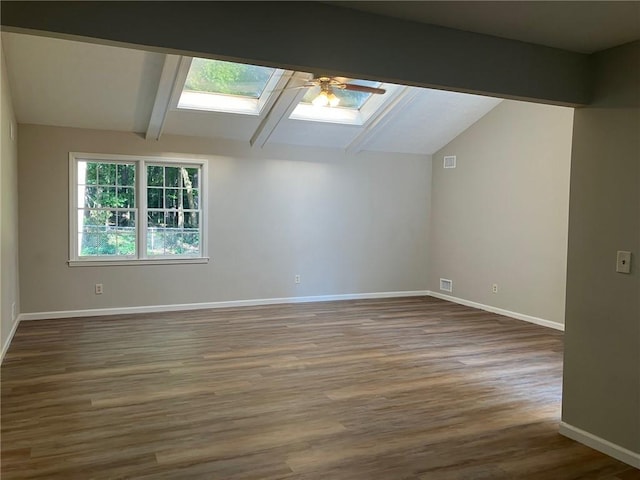 additional living space featuring lofted ceiling with skylight and dark hardwood / wood-style floors