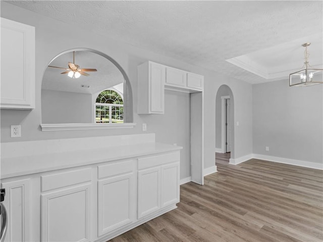 220 Sugar Hill Ct, Jackson, GA 30233 - kitchen with arched walkways, a textured ceiling, wood finished floors, ceiling fan, and white cabinets