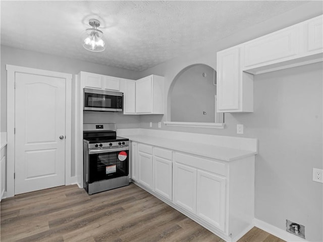 220 Sugar Hill Ct, Jackson, GA 30233 - kitchen with stainless steel appliances, light countertops, white cabinetry, wood finished floors, and a textured ceiling