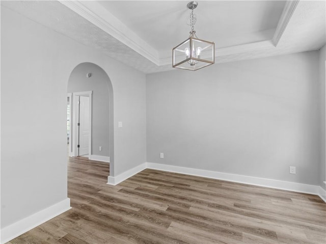 220 Sugar Hill Ct, Jackson, GA 30233 - unfurnished dining area with a raised ceiling, arched walkways, wood finished floors, baseboards, and a chandelier