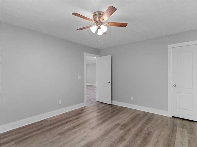 220 Sugar Hill Ct, Jackson, GA 30233 - unfurnished bedroom featuring wood finished floors, baseboards, and a ceiling fan