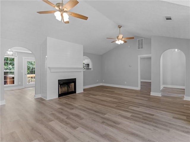 220 Sugar Hill Ct, Jackson, GA 30233 - unfurnished living room featuring a ceiling fan, arched walkways, a large fireplace, wood finished floors, and high vaulted ceiling