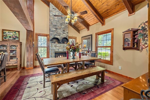 259 Eagle Chase Cir, Dillard, GA 30537 - dining room featuring a stone fireplace, ceiling fan, wood finished floors, a wooden ceiling with exposed beams, and high vaulted ceiling