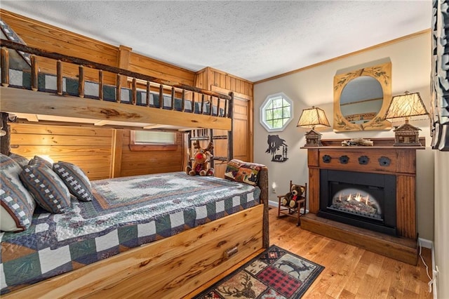 259 Eagle Chase Cir, Dillard, GA 30537 - bedroom featuring wood finished floors, crown molding, a textured ceiling, and a lit fireplace