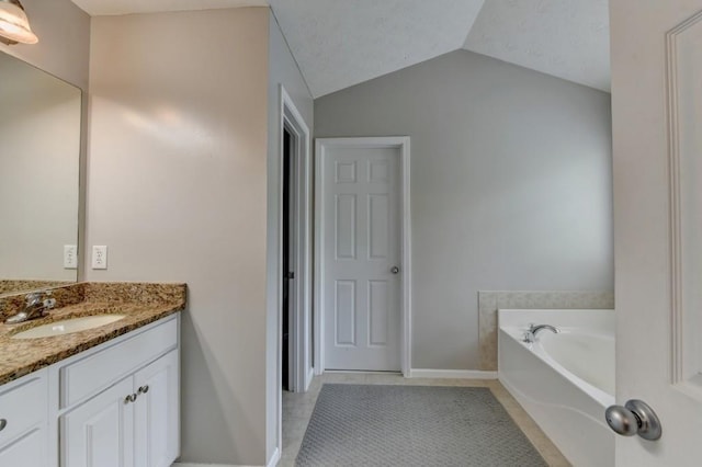 bathroom featuring tile patterned flooring, vanity, a bathtub, and lofted ceiling