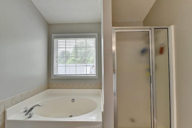 bathroom featuring shower with separate bathtub and a textured ceiling