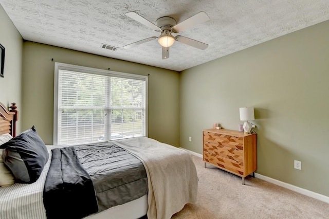 carpeted bedroom featuring a textured ceiling and ceiling fan