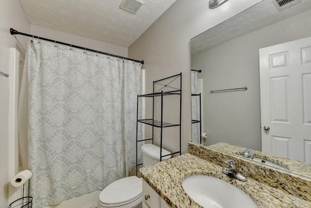 bathroom featuring vanity, toilet, and a textured ceiling