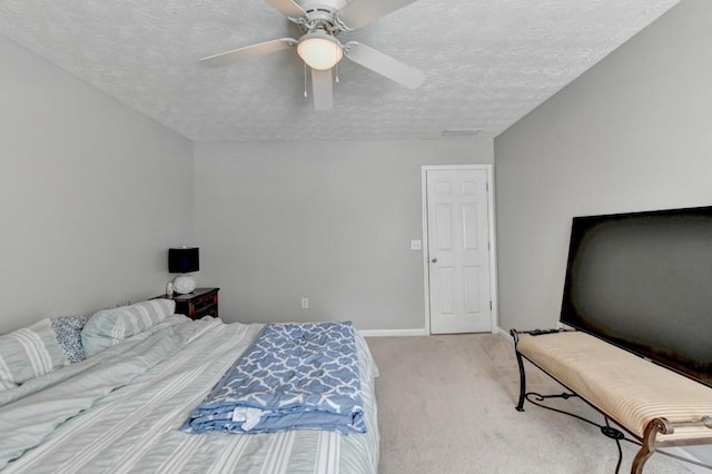 carpeted bedroom featuring ceiling fan and a textured ceiling