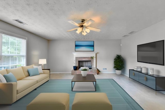 carpeted living room with a textured ceiling and ceiling fan