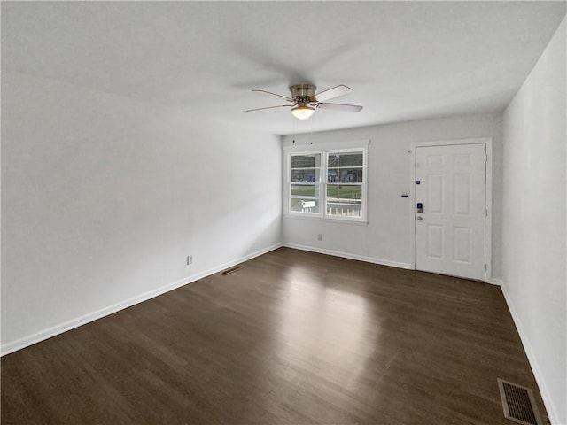 interior space with baseboards, visible vents, dark wood-style flooring, and ceiling fan