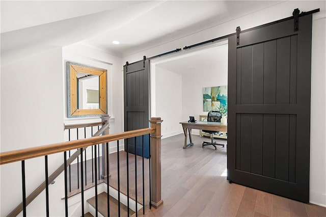 office featuring hardwood / wood-style flooring and a barn door