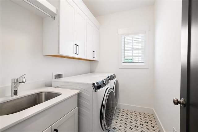 clothes washing area featuring sink, cabinets, and independent washer and dryer