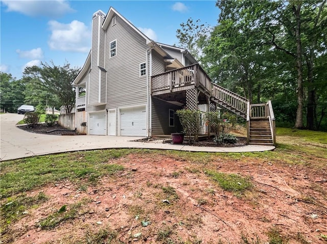 643 Windy Mill Way, Temple, GA 30179 - view of home's exterior featuring stairway, a garage, a chimney, a wooden deck, and concrete driveway