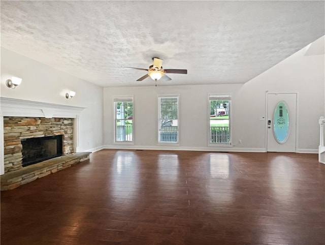 643 Windy Mill Way, Temple, GA 30179 - unfurnished living room with wood finished floors, a textured ceiling, ceiling fan, and a stone fireplace
