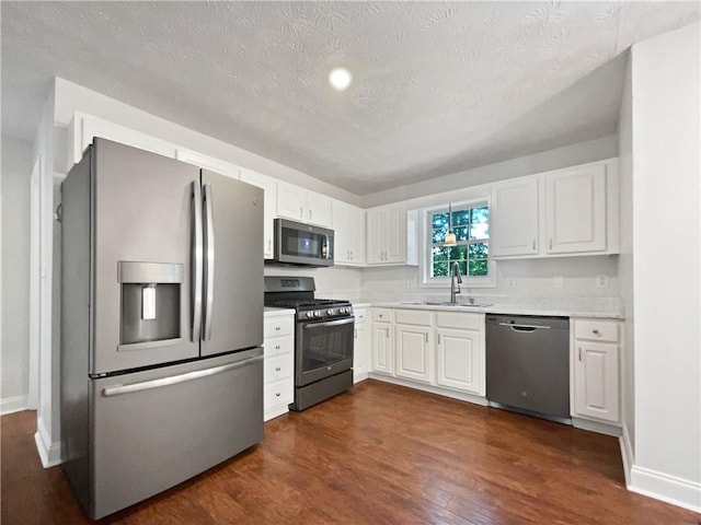 643 Windy Mill Way, Temple, GA 30179 - kitchen with stainless steel appliances, light countertops, dark wood-style flooring, white cabinetry, and a textured ceiling