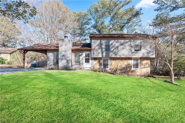 back of property featuring a lawn and a carport