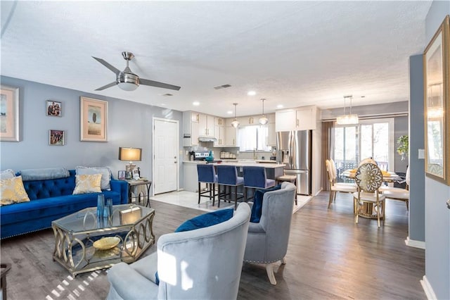 living room with light hardwood / wood-style floors and ceiling fan