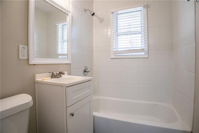 full bathroom featuring toilet, tiled shower / bath combo, and vanity