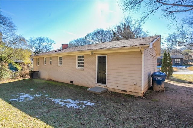 rear view of property featuring central AC unit and a yard