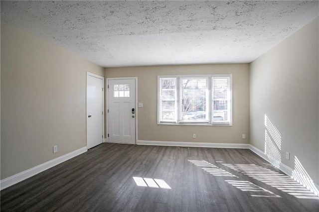 foyer entrance with a textured ceiling and dark hardwood / wood-style floors