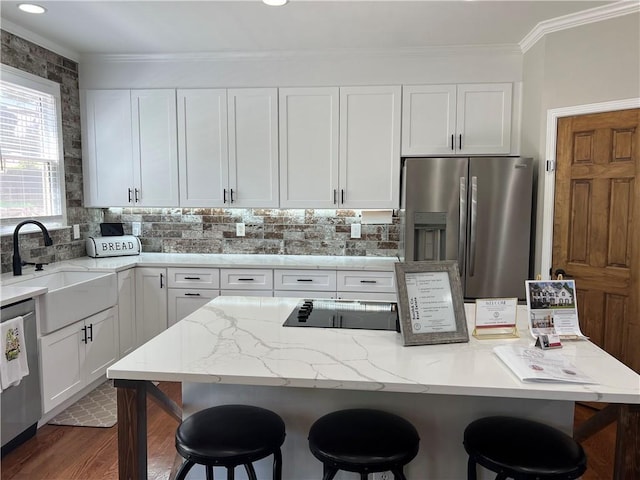 434 Beachwood Dr, Cornelia, GA 30531 - kitchen featuring stainless steel appliances, a sink, crown molding, a kitchen bar, and white cabinets