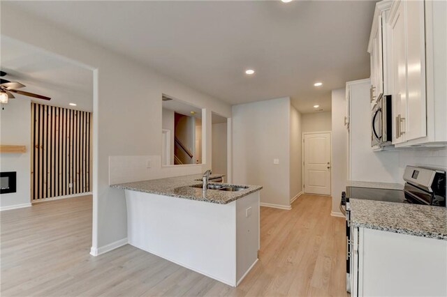 kitchen featuring light stone counters, appliances with stainless steel finishes, sink, and white cabinets