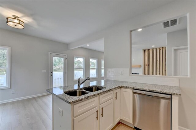 kitchen featuring kitchen peninsula, sink, light wood-type flooring, stainless steel dishwasher, and white cabinetry