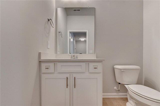 bathroom featuring toilet, hardwood / wood-style flooring, and vanity