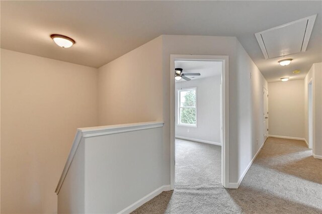 hallway featuring light colored carpet