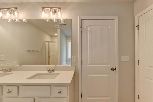 bathroom with a shower with door and vanity