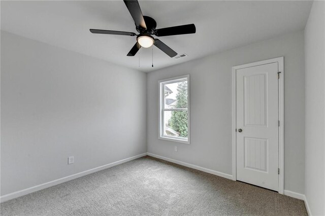 spare room with carpet floors and ceiling fan