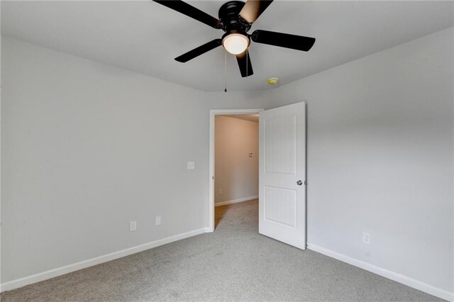 spare room featuring light carpet and ceiling fan