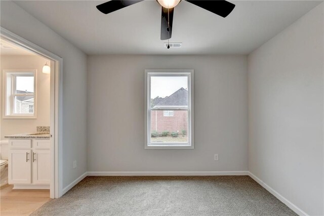 spare room featuring light carpet and ceiling fan