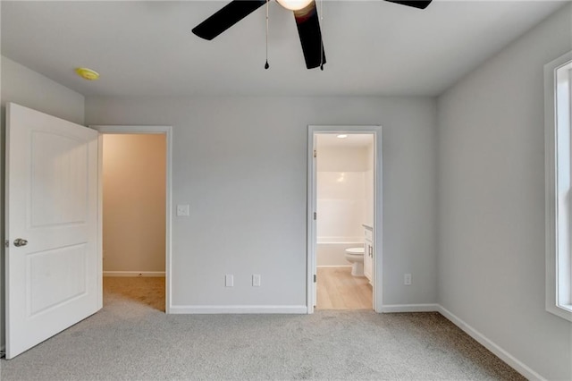 unfurnished bedroom with light carpet, ensuite bath, and ceiling fan