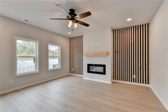 unfurnished living room featuring ceiling fan and light hardwood / wood-style flooring