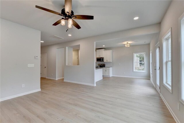 unfurnished living room featuring light wood-type flooring and ceiling fan