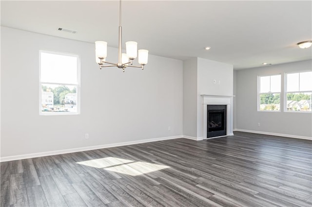 unfurnished living room with a chandelier and dark hardwood / wood-style floors