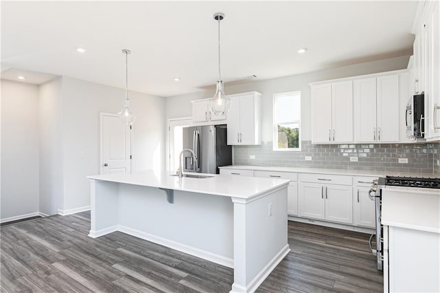 kitchen with white cabinets, stainless steel appliances, and a kitchen island with sink