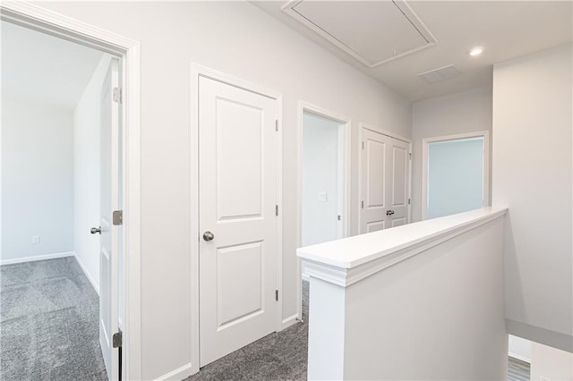 hallway with dark colored carpet