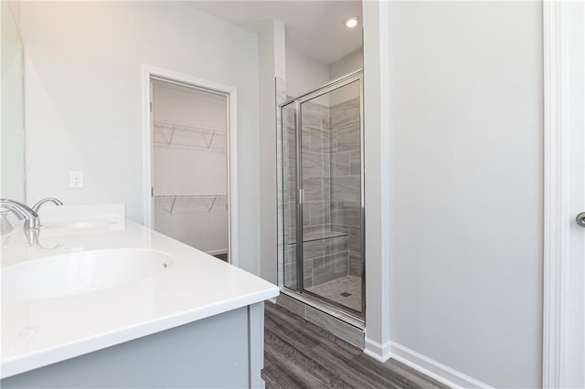 bathroom featuring hardwood / wood-style floors, vanity, and walk in shower