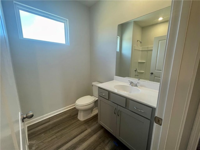 bathroom with hardwood / wood-style floors, toilet, a shower, and vanity