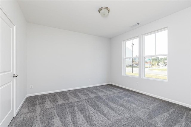 unfurnished room with dark carpet