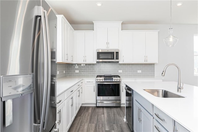 kitchen featuring white cabinets, pendant lighting, and appliances with stainless steel finishes